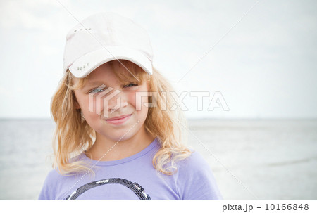 Portrait of a slightly smiling little blond beautiful Russian girl on the sea coast Portrait of a slightly smiling little blond beautiful Russian girl on the sea coast 10166848