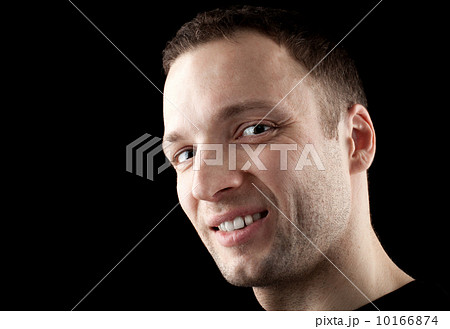 Young Caucasian man darkly smirks. Close-up portrait in the dark Young Caucasian man darkly smirks. Close-up portrait in the dark 10166874
