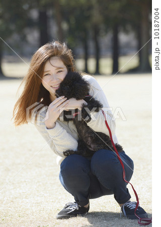 犬と遊ぶ若いカップル 10187004