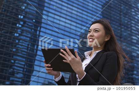Asian business woman working outdoors with a tablet Asian business woman working outdoors with a tablet 10195055
