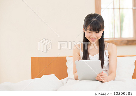 ベッドでタブレットをする女性 10200585