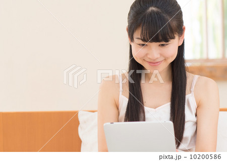ベッドでタブレットをする女性 10200586