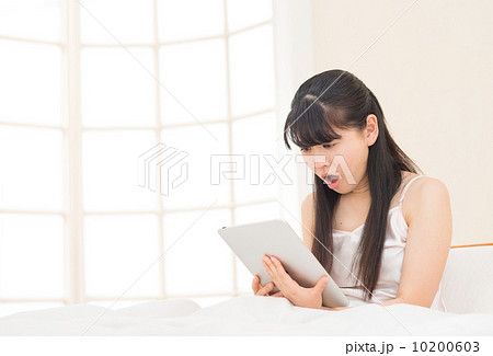 ベッドでタブレットをする女性 10200603