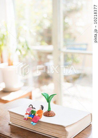 本の上で成長を見守る家族と植物の粘土細工 10218377