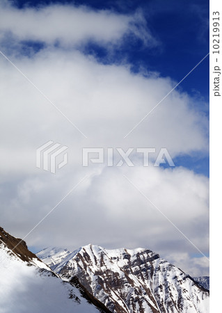Winter snowy mountains and sky with clouds at sun day 10219913