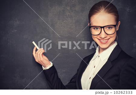 business woman teacher with glasses and a suit with chalk at a business woman teacher with glasses and a suit with chalk at a 10262333