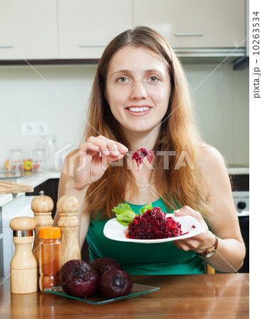 Casual  girl in green eating boiled beets 10263534