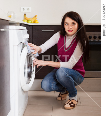 brunette woman cleaning washing machine 10263897
