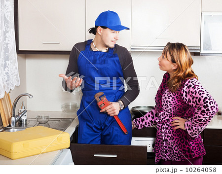 Housewife watching as man repairing 10264058