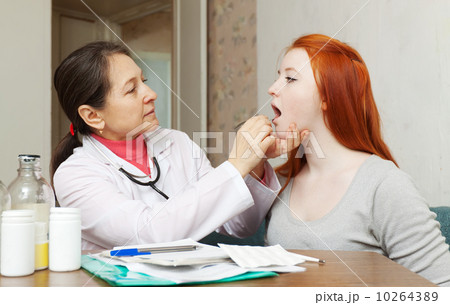 doctor looks throat of teenager 10264389