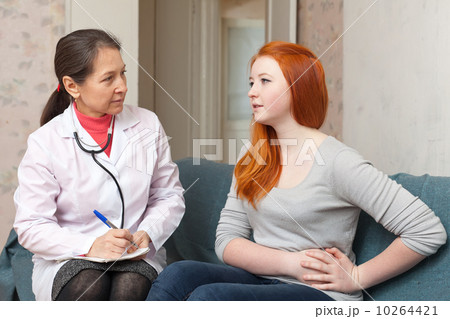 girl complaining  to doctor about stomach ache 10264421