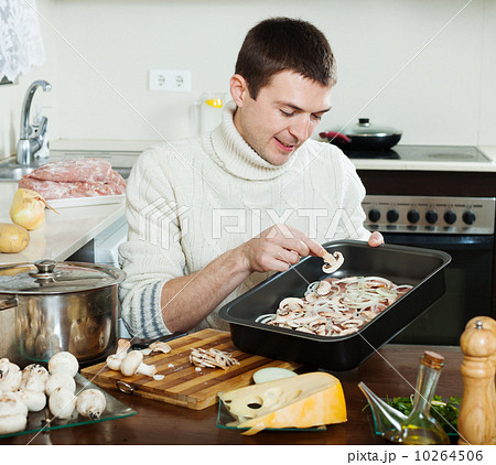 Handsome man cooking meat with mushrooms Handsome man cooking meat with mushrooms 10264506