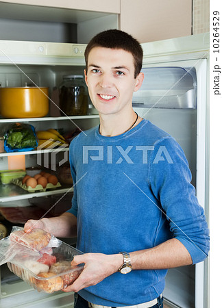 guy  near opened refrigerator in kitchen 10264529
