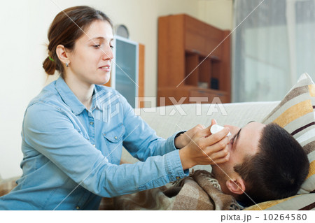 Caring woman dripping collyrium to husband 10264580
