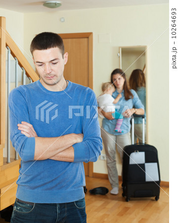 Sad man against wife with baby and suitcase Sad man against wife with baby and suitcase 10264693