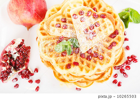Crisp golden fresh baked waffle topped with strawberries on whit 10265503