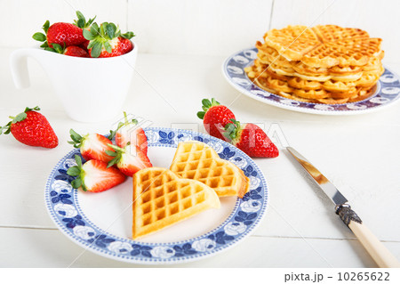 Crisp golden fresh baked waffle topped with strawberries on whit 10265622