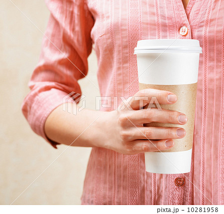 Young woman holding a tumbler of coffee Young woman holding a tumbler of coffee 10281958