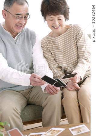 ポラロイドの写真を見るシニア夫婦 10282464