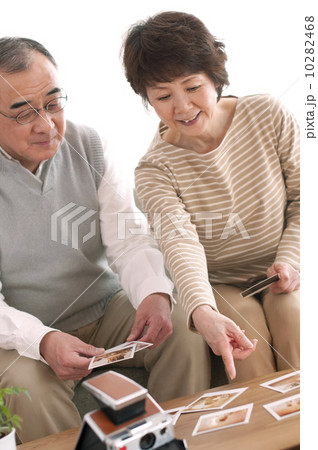 ポラロイドの写真を見るシニア夫婦 10282468