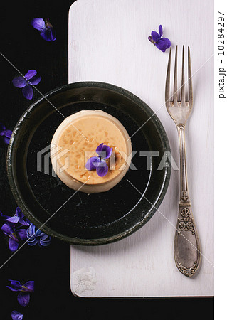Caramel pannacotta with violet flowers Caramel pannacotta with violet flowers 10284297