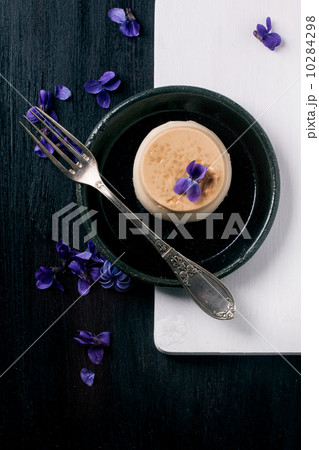 Caramel pannacotta with violet flowers 10284298