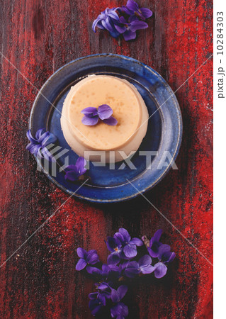 Caramel pannacotta with violet flowers 10284303
