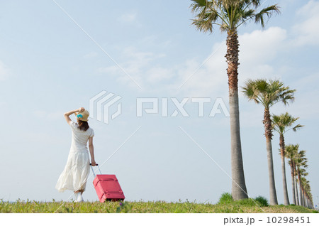 スーツケースを持って歩く女性 10298451