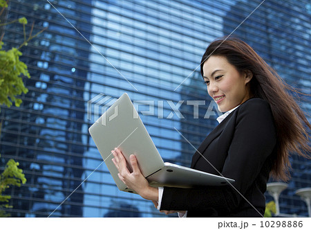 Asian business woman working outdoors with a laptop computer Asian business woman working outdoors with a laptop computer 10298886