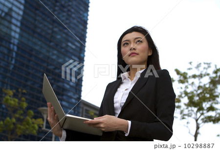 Asian business woman working outdoors with a laptop computer Asian business woman working outdoors with a laptop computer 10298887