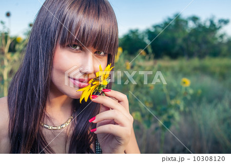 Women smelling sunflower Women smelling sunflower 10308120