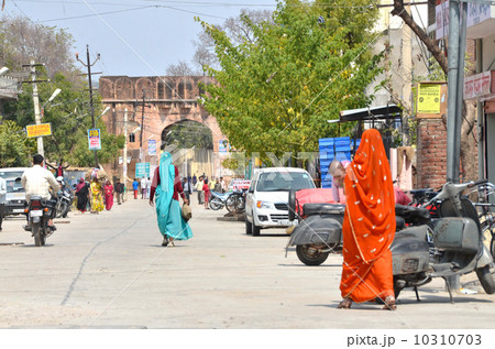 原色のサリーを来た女性達が行きかうジャイプルの城門前 10310703