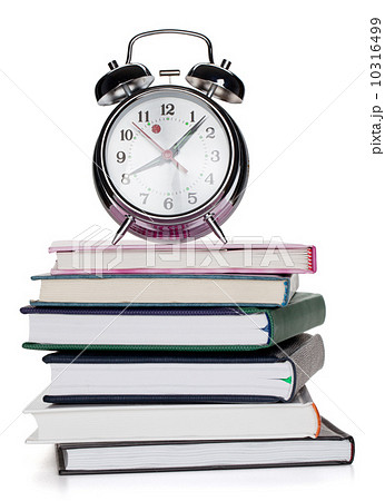Alarm clock on notepads and books 10316499