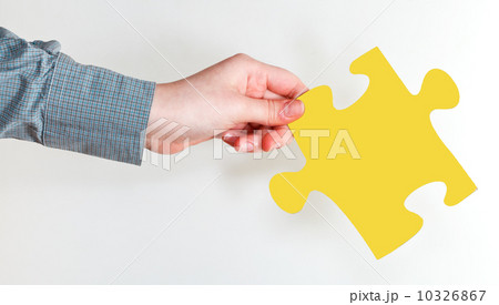 female hand holding yellow puzzle piece 10326867