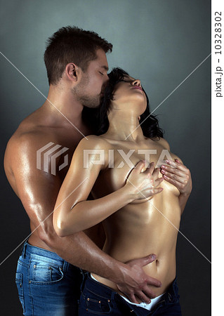 Tanned passionate lovers embracing in studio 10328302