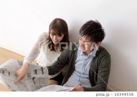 新聞を読む男女 10349556
