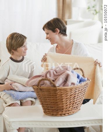 Mother and child folding laundry 10350072