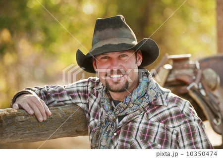 Cowboy leaning on fence Cowboy leaning on fence 10350474