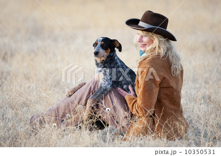 Woman and dog sitting in field 10350531