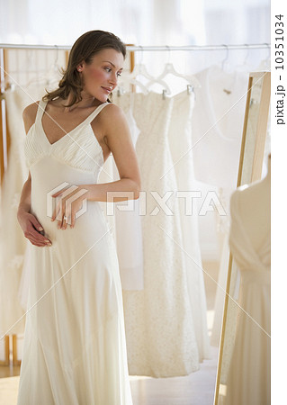 Woman trying on wedding dress Woman trying on wedding dress 10351034