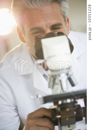 Researcher looking through microscope Researcher looking through microscope 10351228
