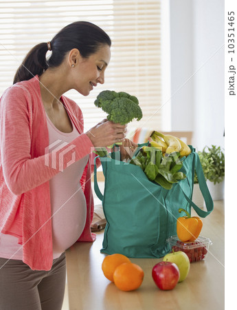 Pregnant woman unpacking groceries 10351465