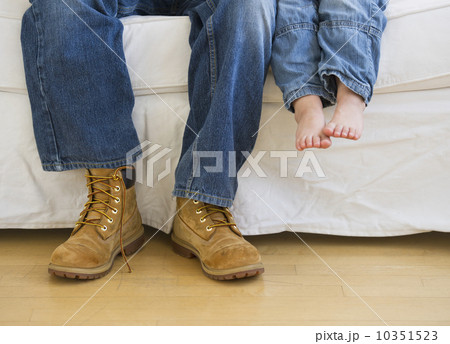 Legs of two people sitting on couch 10351523