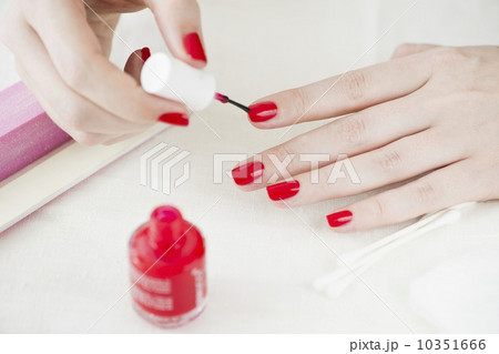 Woman painting her nails with red nail polish Woman painting her nails with red nail polish 10351666