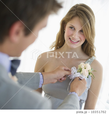 Man pinning corsage on his date's prom dress 10351702