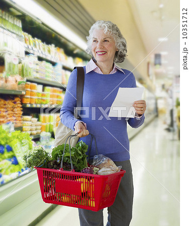 USA, New Jersey, Jersey City, Senior woman carrying shopping basket in supermarket 10351712