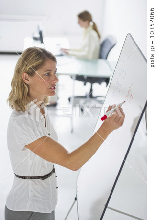 Businesswoman writing on presentation board Businesswoman writing on presentation board 10352066