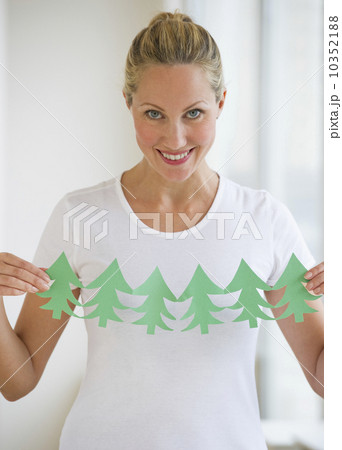 Woman holding cut out of trees Woman holding cut out of trees 10352188