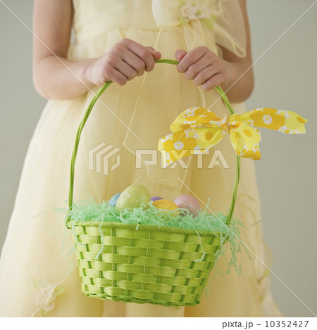 Young girl holding a basket of Easter eggs 10352427
