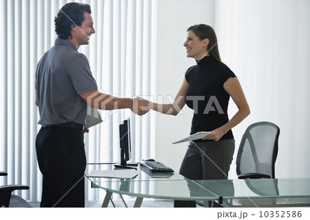 Man and woman in office shaking hands Man and woman in office shaking hands 10352586
